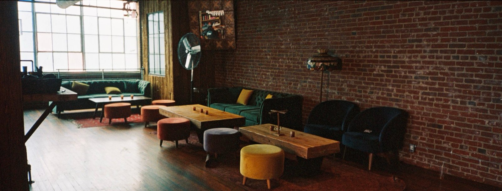 The empty Margolis lounge, blue velvet sofas lined along the brick wall