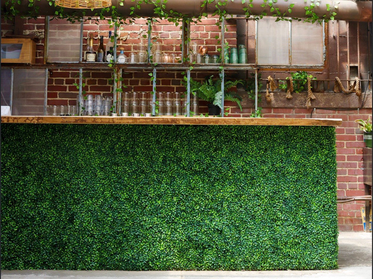 The Patio bar under hanging greenery and rattan lanterns