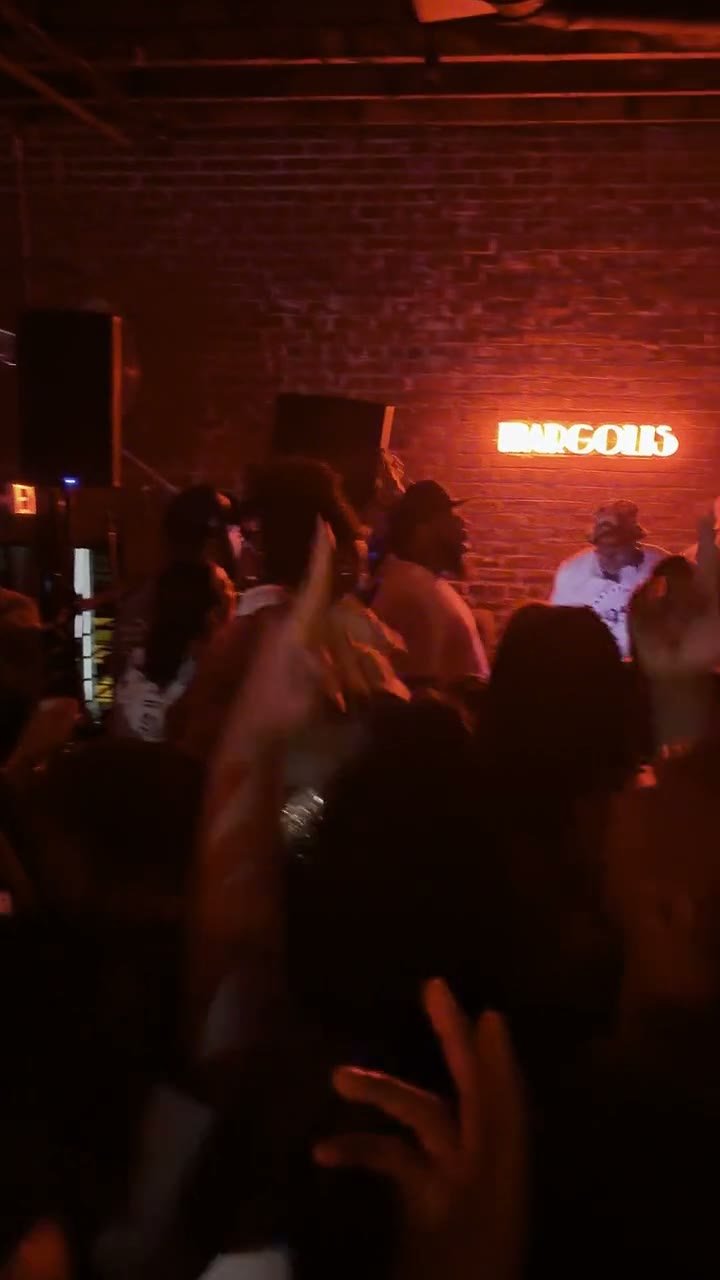 The crowd at Margolis under the neon sign on a full night